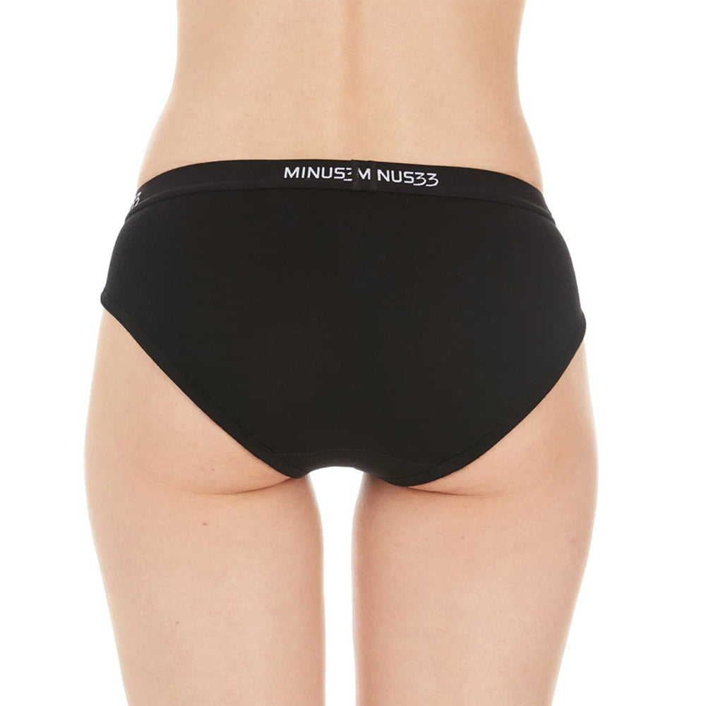 A woman models a pair of super soft merino wool bikini brief underwear. Light and breathable, these briefs feature a 1-inch woven sport elastic band, and high cut leg openings for a better range of movement. #color_black