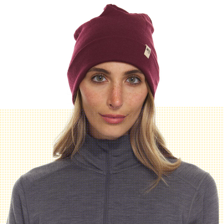 A woman models a lightweight, double-layered, hundred percent, super soft merino wool beanie perfect for fall, winter, and spring. This hat is perfect for a hike up the mountain or a walk around the block!
#color_burgundy