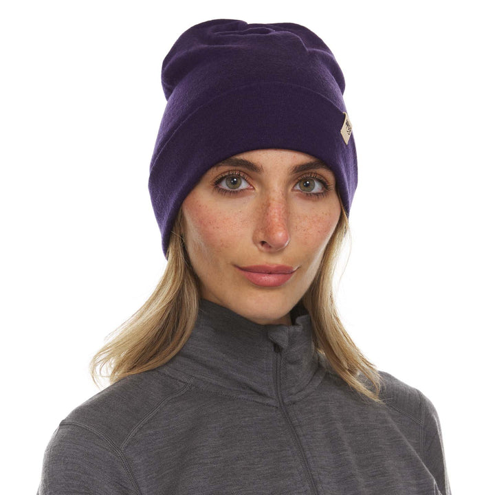 A woman models a lightweight, double-layered, hundred percent, super soft merino wool beanie perfect for fall, winter, and spring. This hat is perfect for a hike up the mountain or a walk around the block!
#color_dark-purple