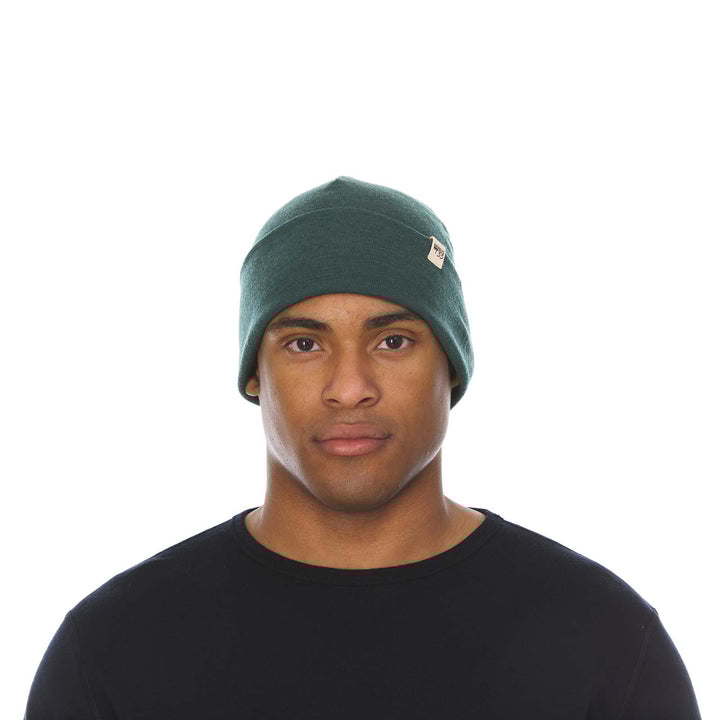 A man models the lightweight, double-layered, hundred percent, super soft merino wool beanie perfect for fall, winter, and spring. This hat is perfect for a hike up the mountain or a walk around the block!
#color_forest-green