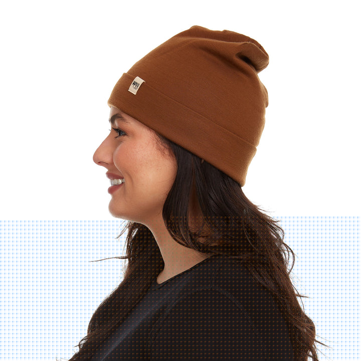 A woman models a lightweight, double-layered, hundred percent, super soft merino wool beanie perfect for fall, winter, and spring. This hat is perfect for a hike up the mountain or a walk around the block!
#color_golden-brown