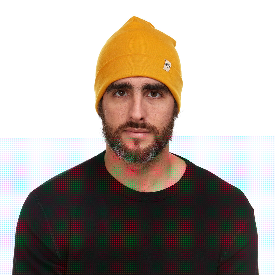 A man models the lightweight, double-layered, hundred percent, super soft merino wool beanie perfect for fall, winter, and spring. This hat is perfect for a hike up the mountain or a walk around the block!
#color_gold