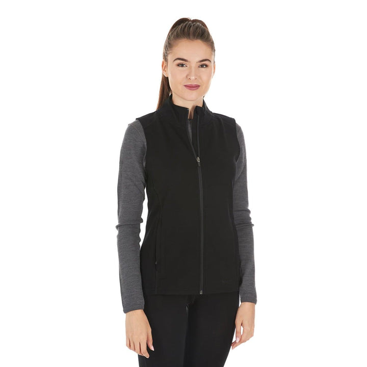 A woman models a hundred percent merino wool heavyweight full zip vest. This outer layer features a two and a half inch mock neck collar and two zippered pockets. #color_black
