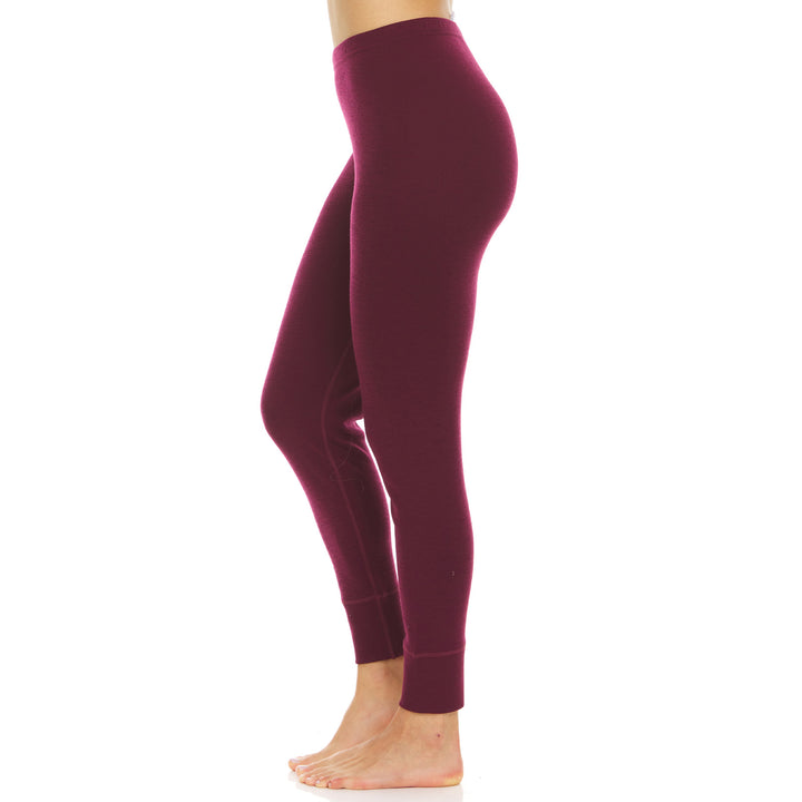 A pair of one hundred percent merino wool midweight women's base layer bottoms. These bottoms feature a gusset between the legs for improved range of motion, and cuffs around the ankles for comfort and style. #color_burgundy